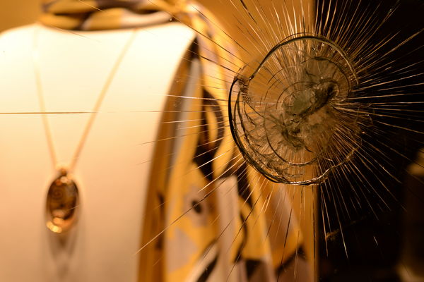 retail store window with bullet hole evidence of organized retail crime