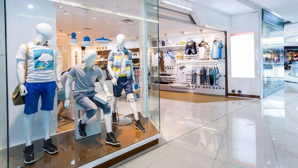 entrance to a casual clothing store in a retail mall with three mannequins in sporty attire in the window