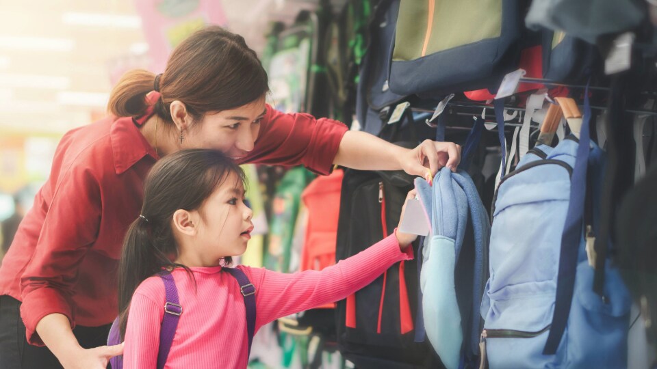 Mom and daughter shopping for school bags