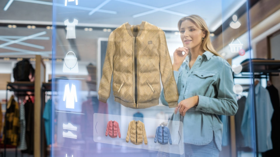 female shopper choosing apparel in retail store using augmented reality computer display