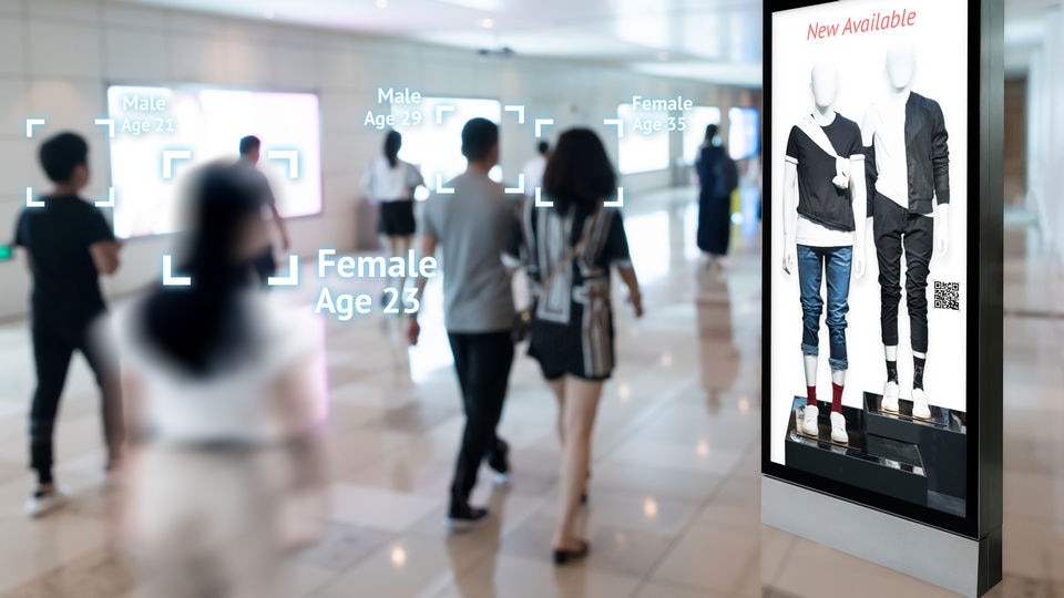 shoppers walking through retail mall identified by augmented reality overlay and responsive electronic signage