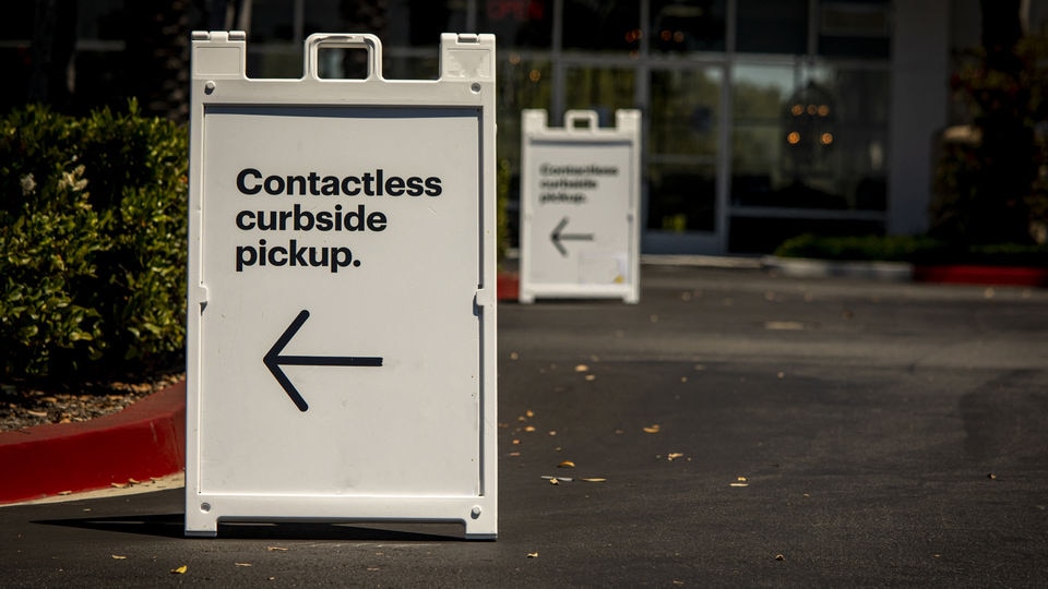portable sign in front of retail store announcing contactless curbside pickup