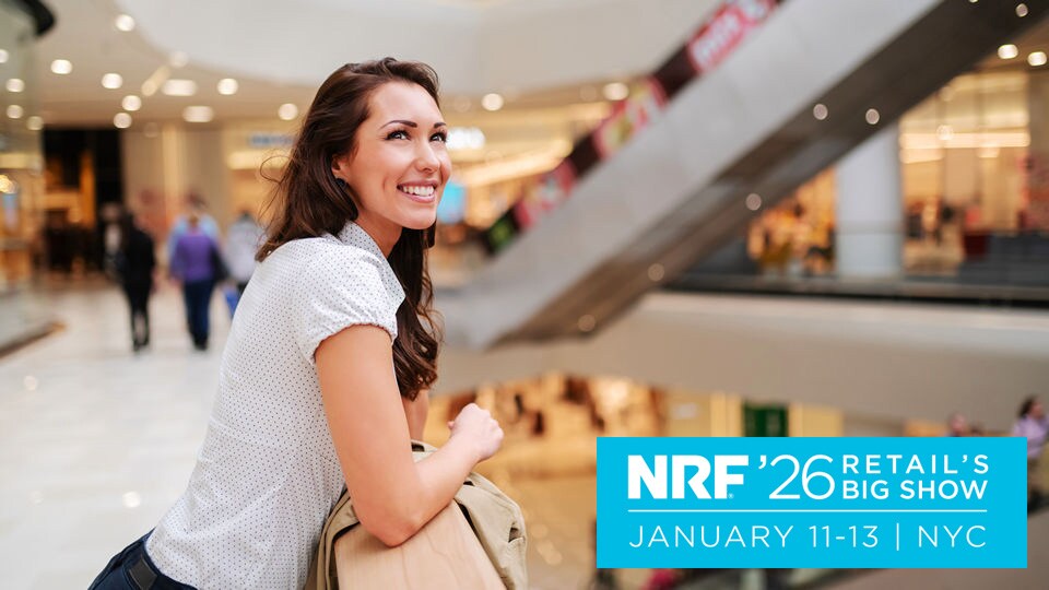 late 20s female shopper looking over an atrium and escalators in a multi-level indoor retail shopping mall with nrf 2026 logo superimposed