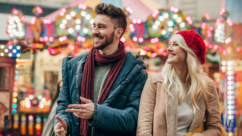 young male female couple in retail shopping area decorated for christmas winter holidays