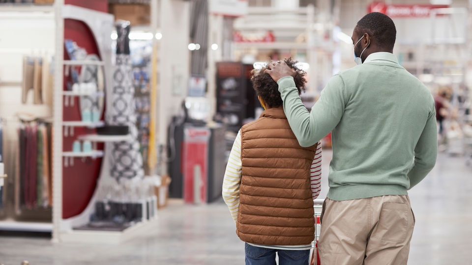 father ruffles child's hair affectionately while shopping in retail store