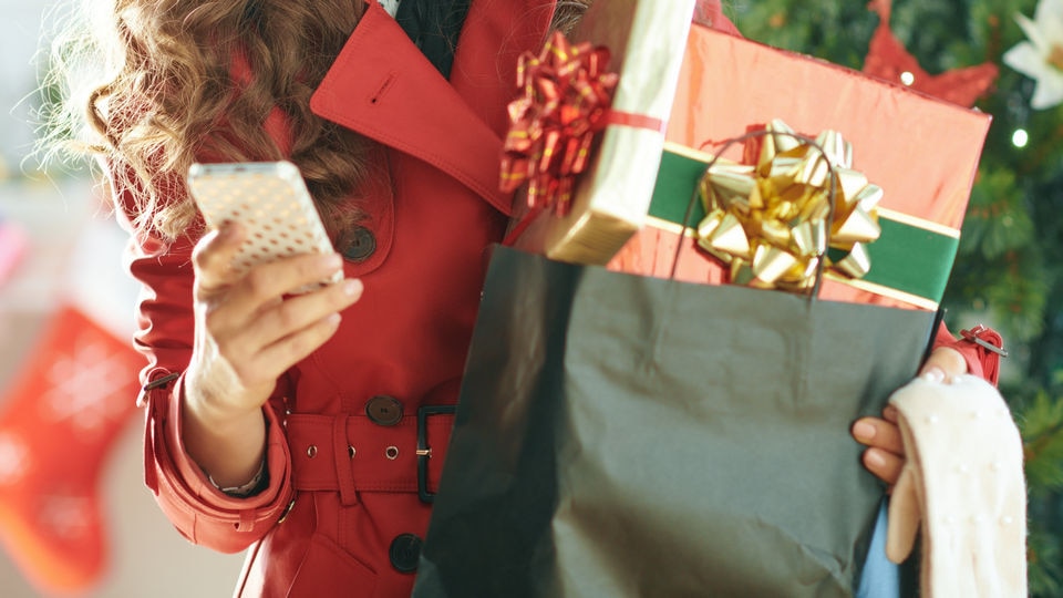 female shopper holing device and bag of holiday gifts