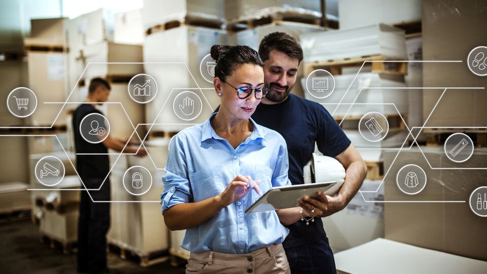 two retail associates in stock room looking at device