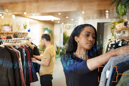 woman shopping in busy retail apparel store with another shopper in the background and numbers superimposed as data on top of the image