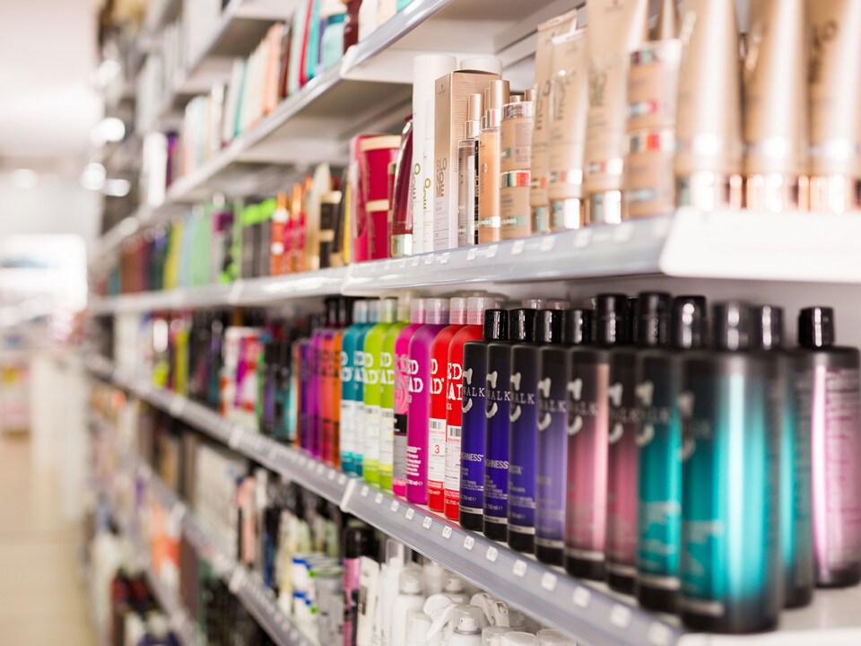 colorful bottles and cans of health and beauty products displayed on shelf in brightly lit retail store