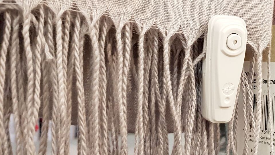 sensormatic infuzion hard tag attached to scarf in retail apparel store