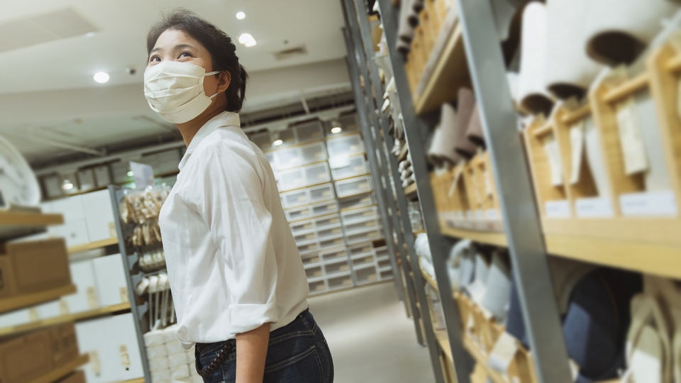 masked female retail employee in store stockroom