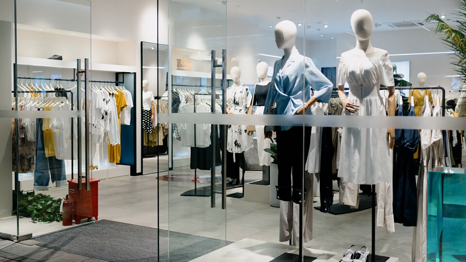 storefront of a retail apparel store with several mannequins in the store window