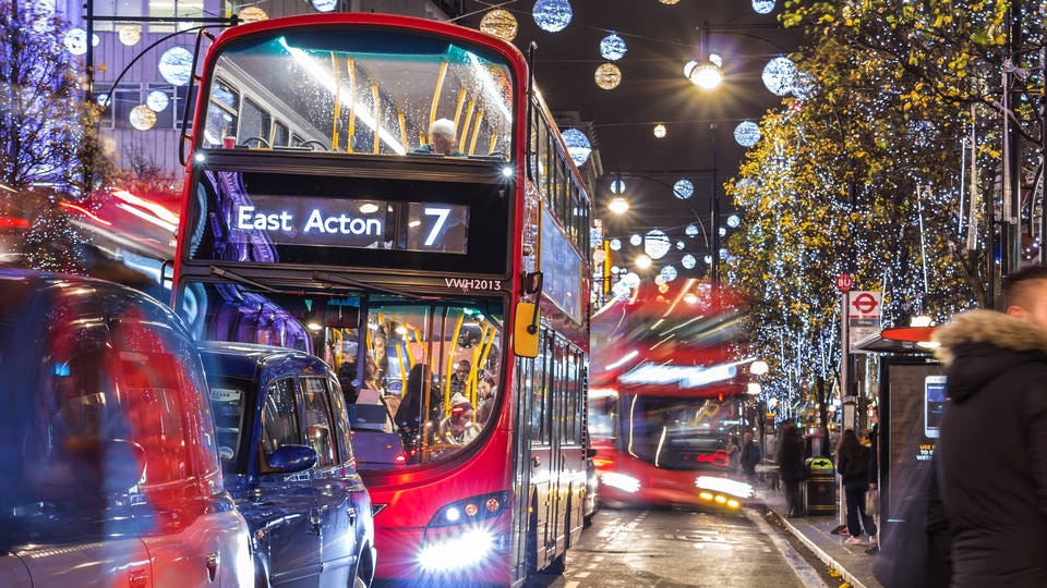 london double-decker bus on busy holiday decorated uk street