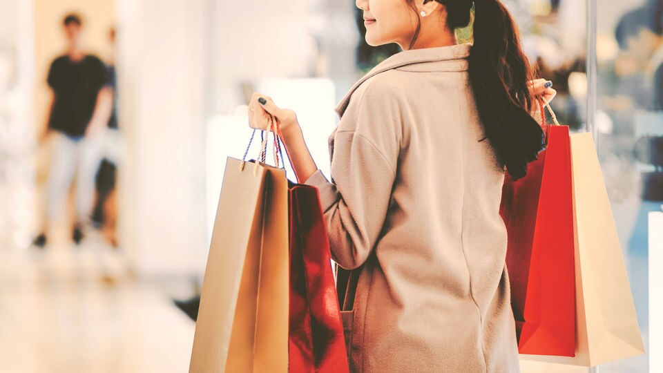 woman with shopping bags in retail shopping mall