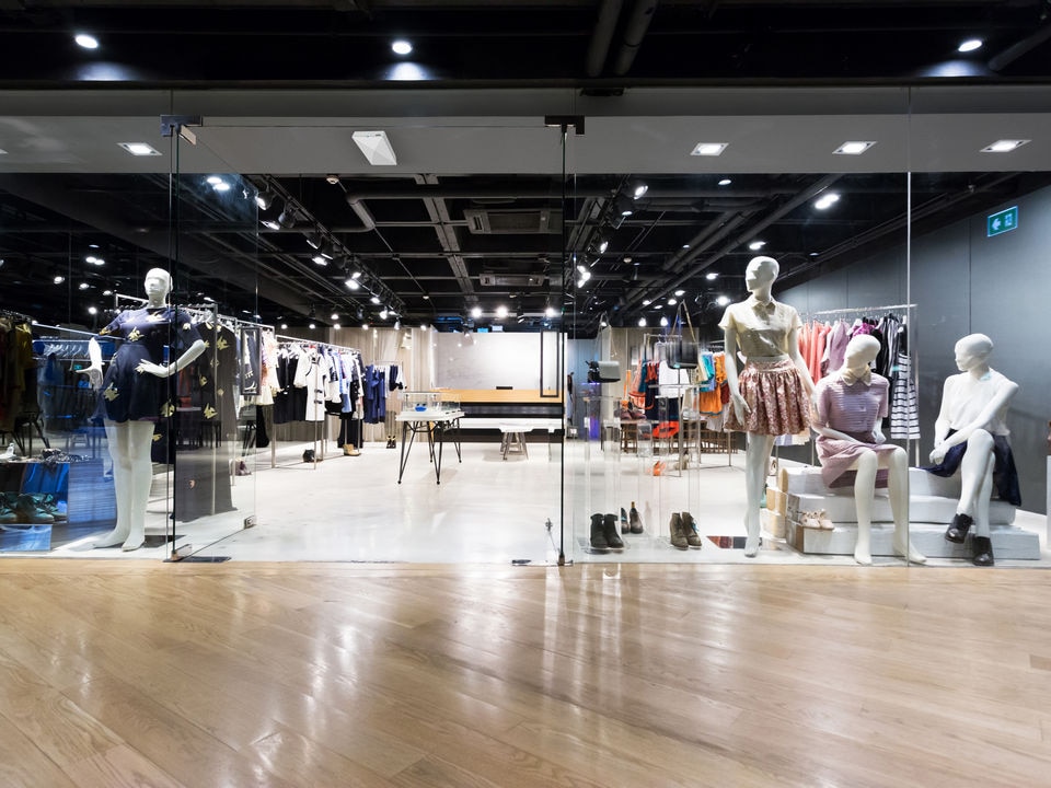 entrance and interior of modern retail apparel store with several mannequins