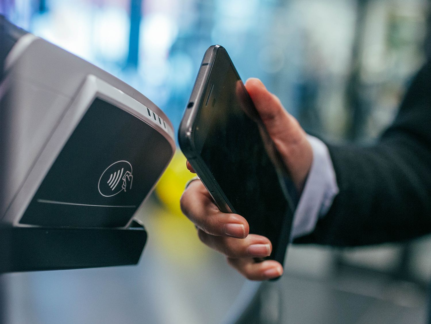 man's hand holding cellphone up to scanner