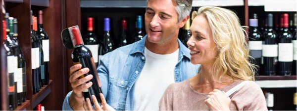 Couple shopping for wine bottle with Sensormatic anti-theft tag
