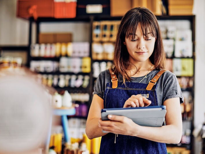 Retail store associate examines inventory intelligence on mobile device