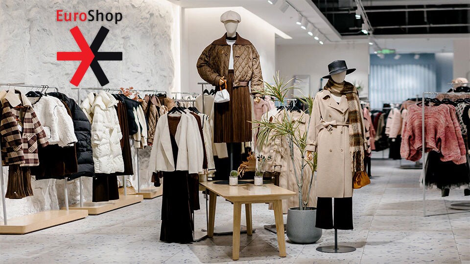 interior of high end apparel retail store with two mannequins in the center and euroshop logo superimposed