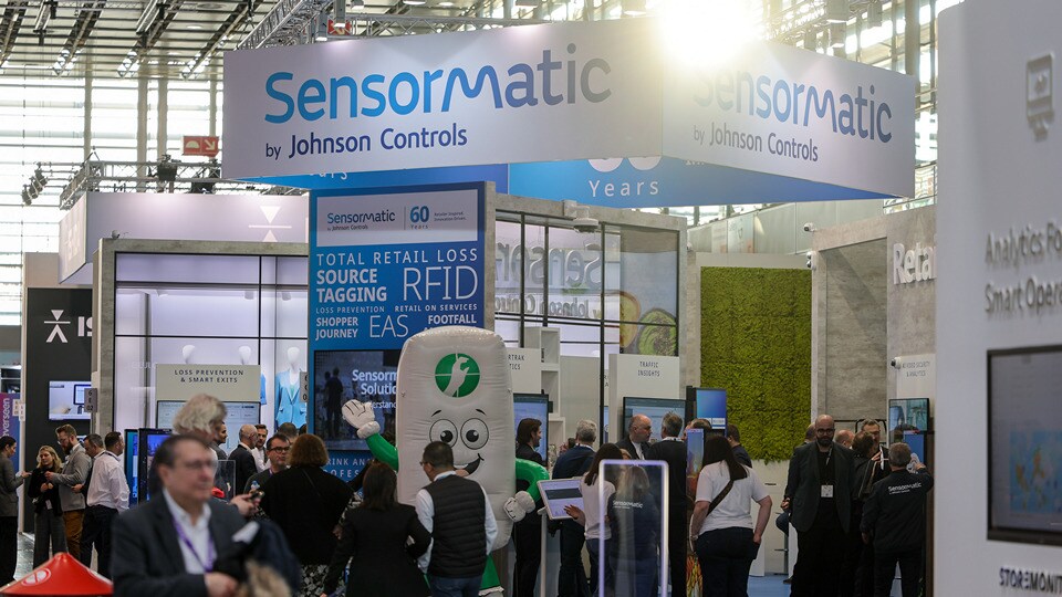 sensormatic booth at 2025 uk retail technology show with midday sunlight shining through the convention hall window