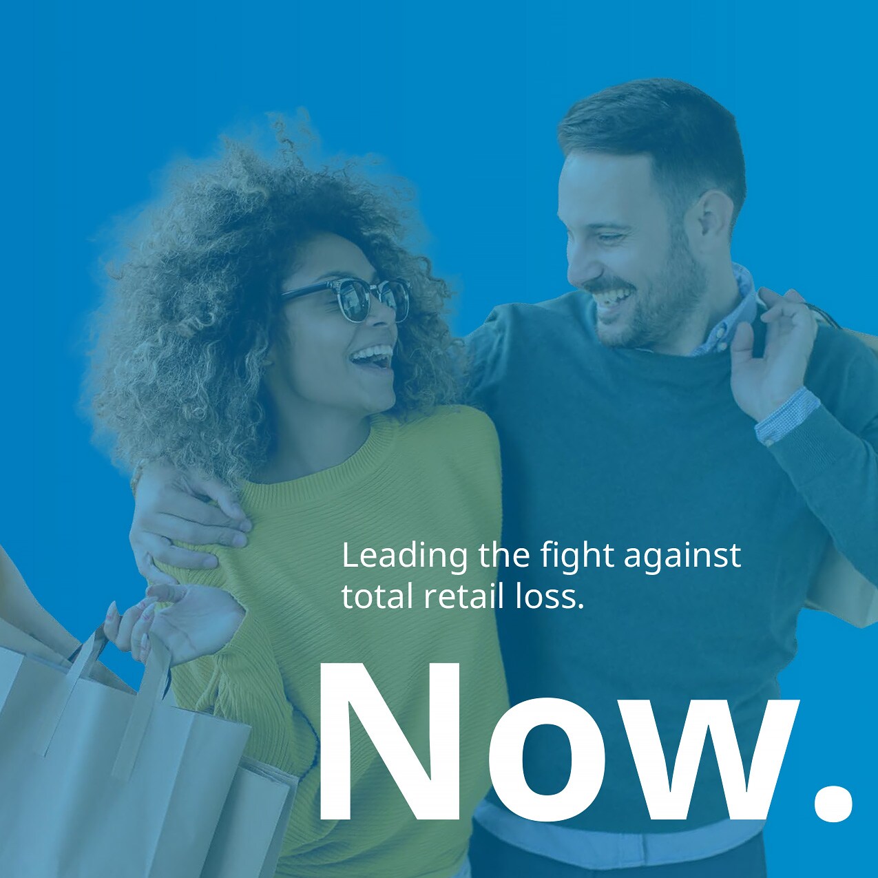 sensormatic 60th anniversary redefining retail carousel slide 3: mixed race male and female couple laughing and carrying shopping bags from an apparel store. text: now. leading the fight against total retail loss.