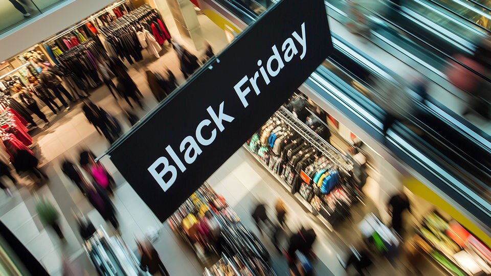 overhead view of busy retail shopping center mall with sign hanging above announcing black friday