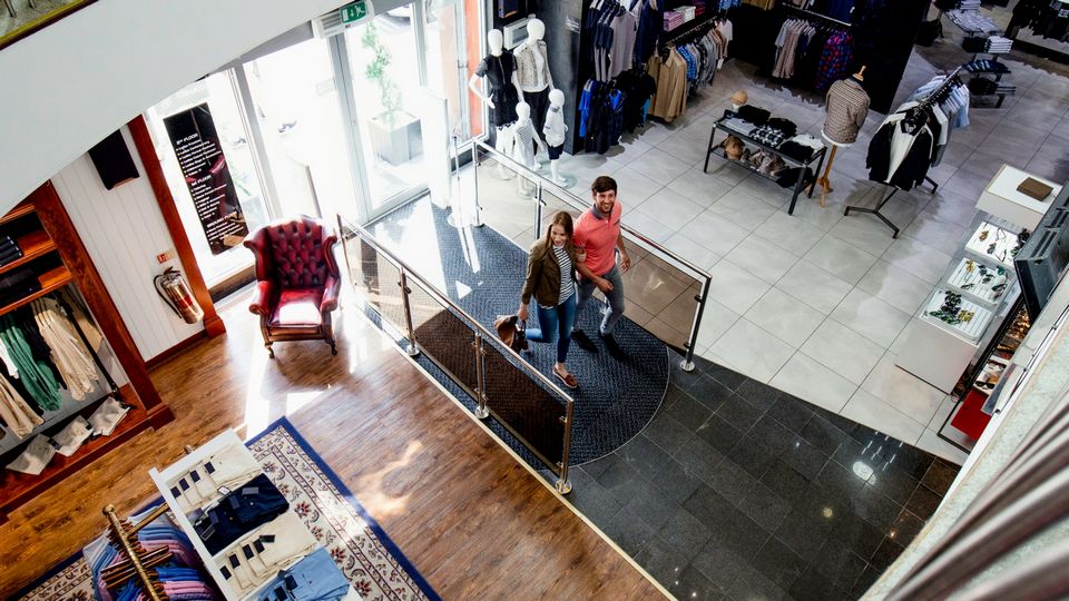 male female couple entering retail apparel store for shopping