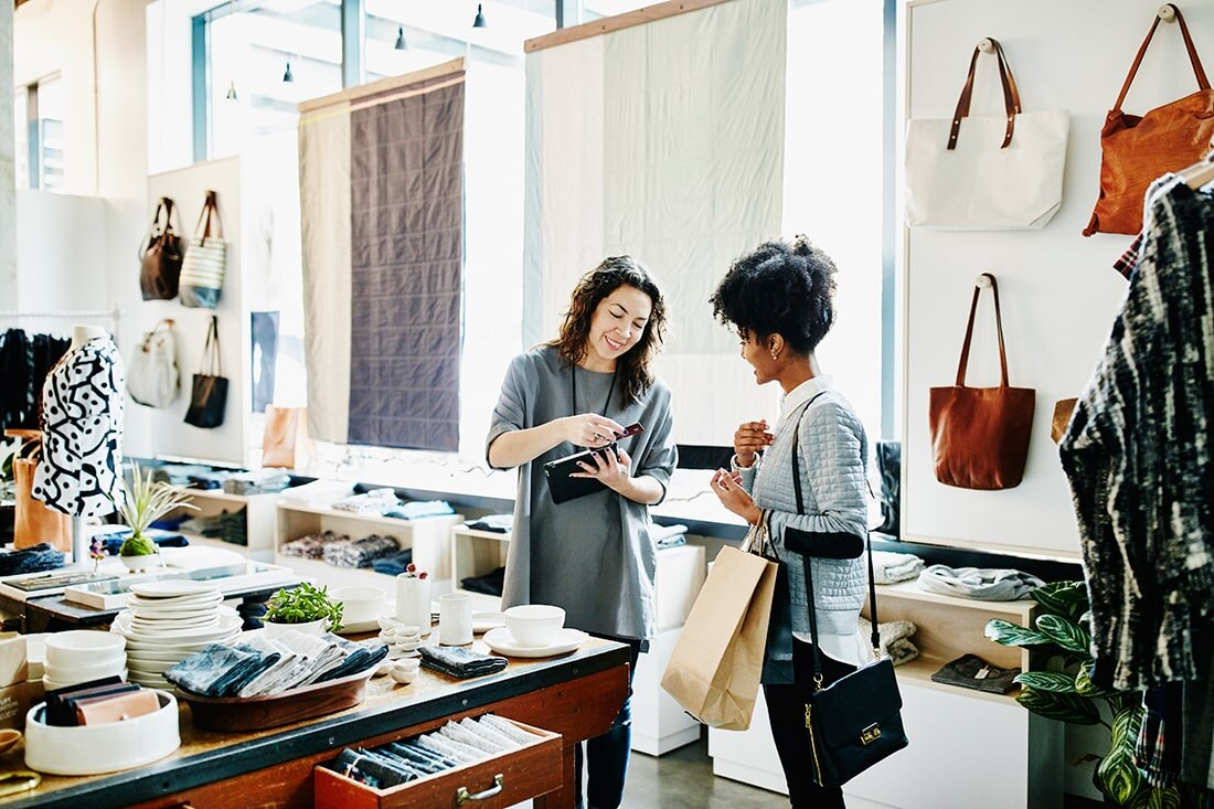 Retailer helping shopper in fashion accessory store