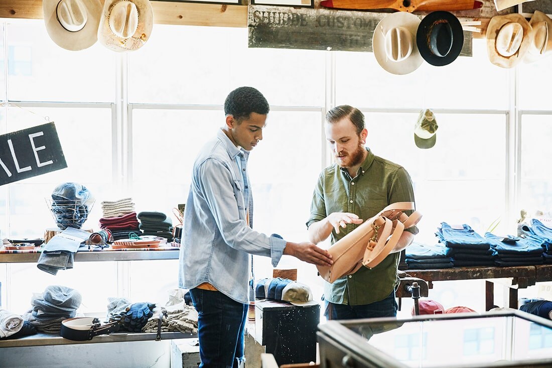 Retail associate helping shopper with bag
