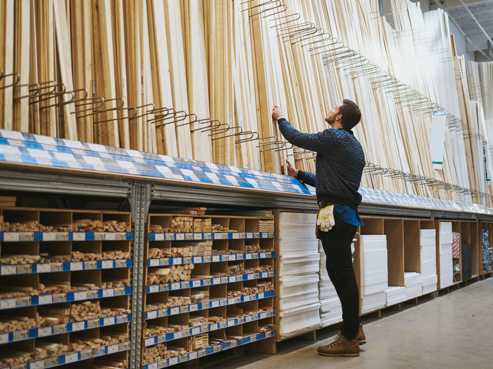man browsing display of lumber in retail hardware diy store