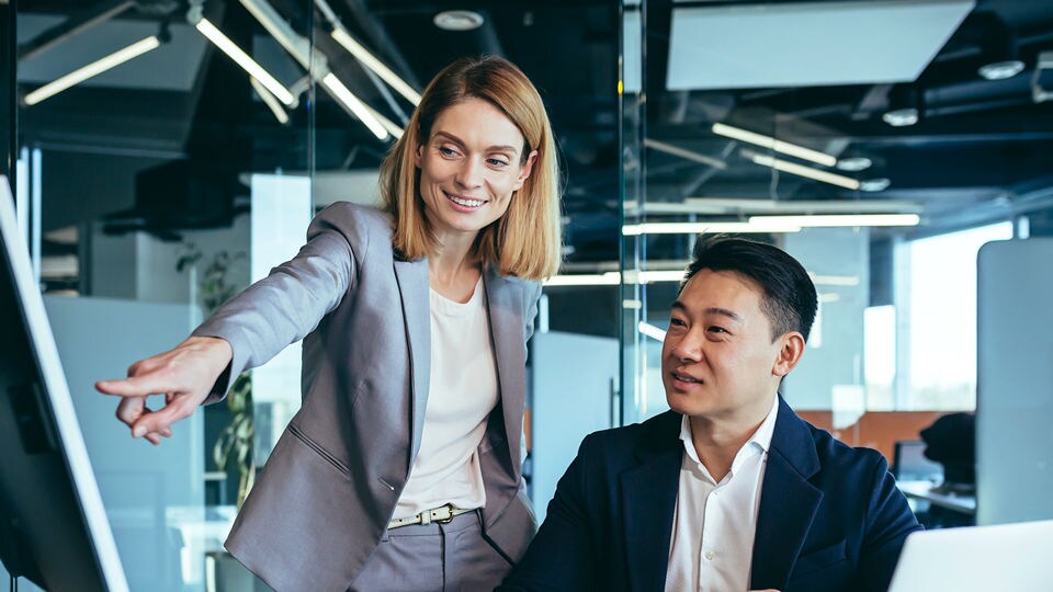 two retail managers employees reviewing store data on a computer in an office setting