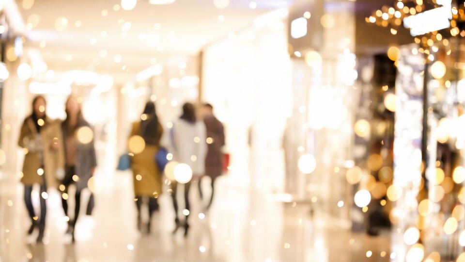 artistically blurred image of shoppers in a retail shopping center