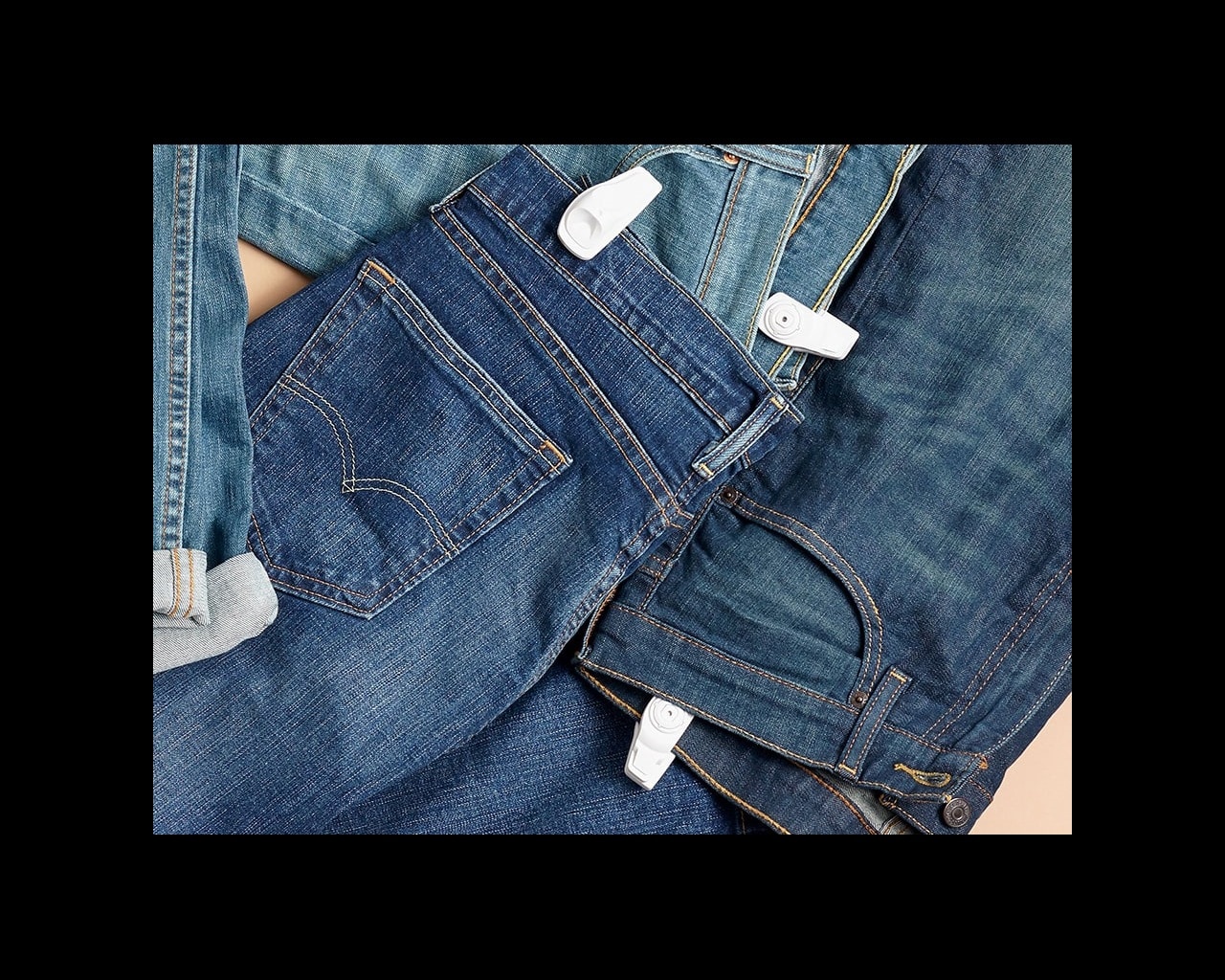 pairs of jeans on a surface with infuzion hard tags