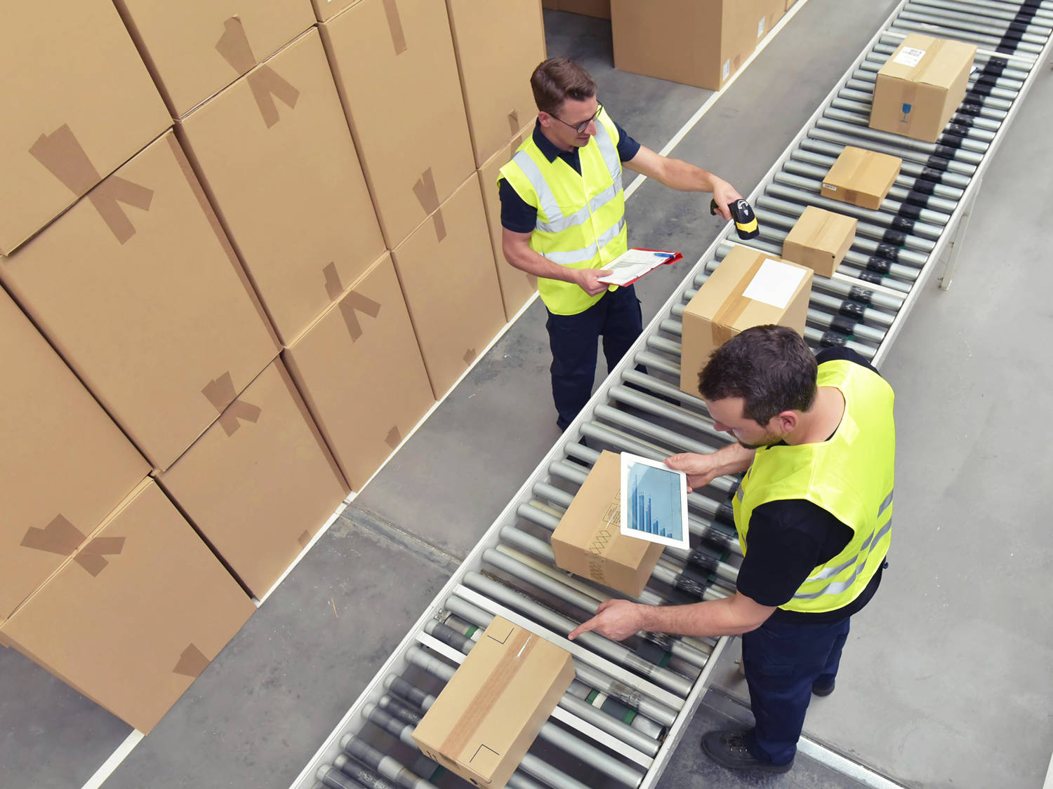 two male warehouse employees scanning packages
