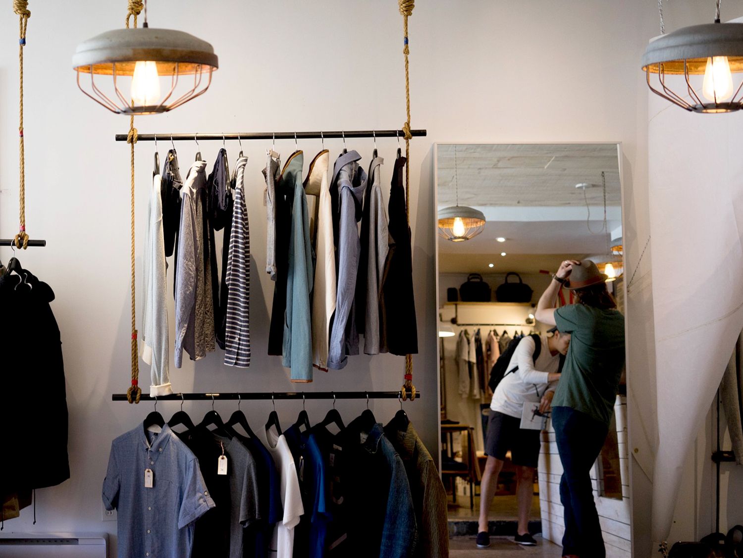 Ropa colgada en un estante de 2 niveles en una tienda minorista