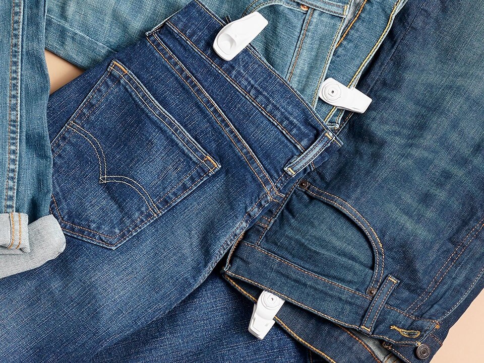 pairs of jeans on a surface with infuzion hard tags