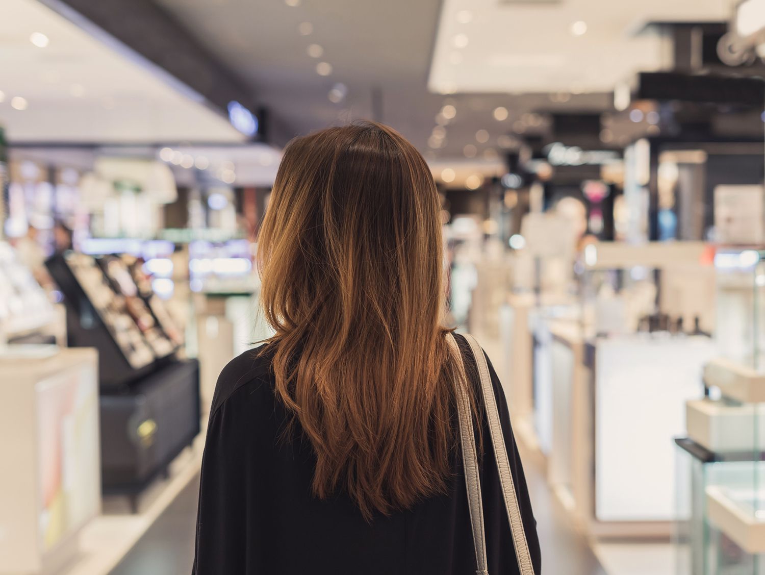 rear view of woman walking down a retail aisle
