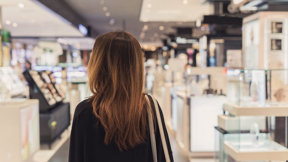 female shopper walking down aisle of retail store