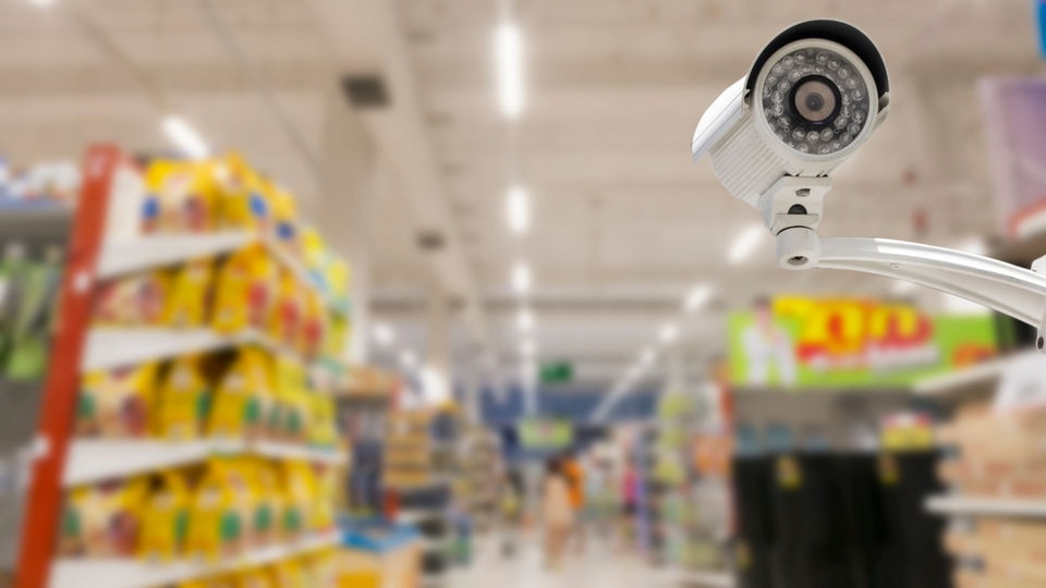 video surveillance camera in aisle of retail grocery store