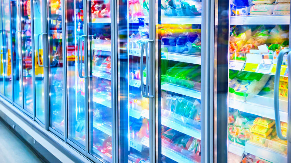 vibrant color image of frozen food cases in retail grocery store refrigerated aisle