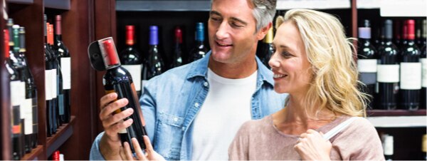 Couple shopping for wine bottle with  Sensormatic anti-theft tag