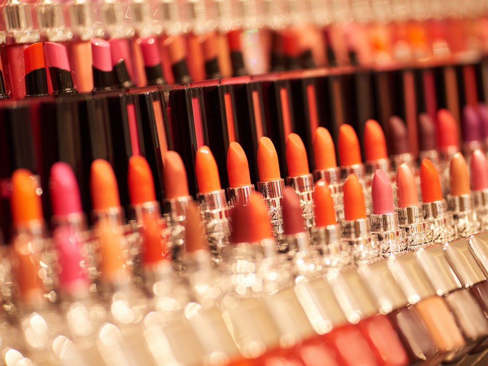 retail display of many hues and styles of lipstick in health and beauty store