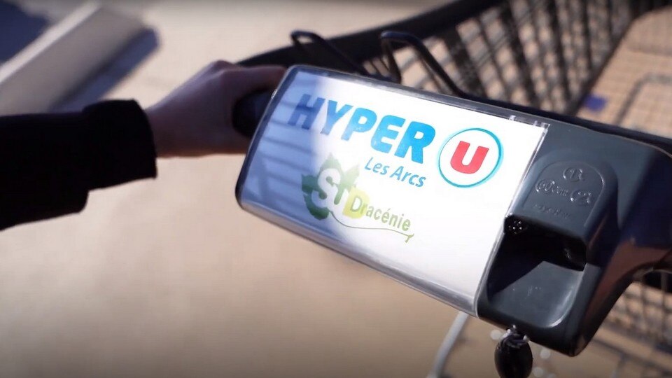 hand pushing shopper cart with hyper-u retailer logo on handle