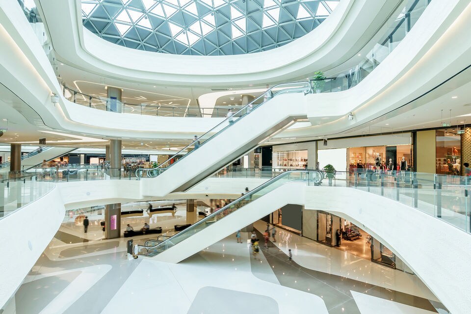 interior of brightly lit modern multi-level indoor busy retail shopping mall