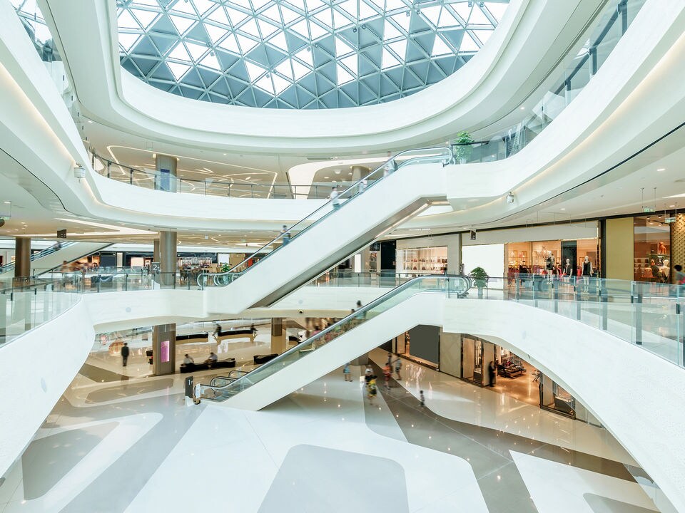 interior of brightly lit modern multi-level indoor busy retail shopping mall