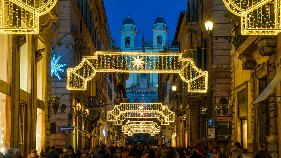 view of retail shopping street with illuminated decorations and classical building in the background