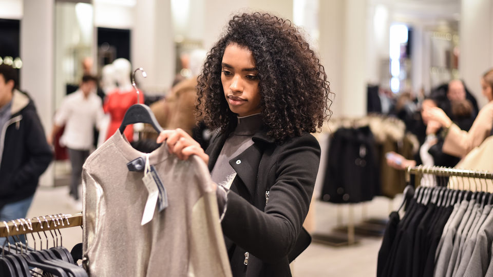 female shopper looking at merchandise in retail apparel store