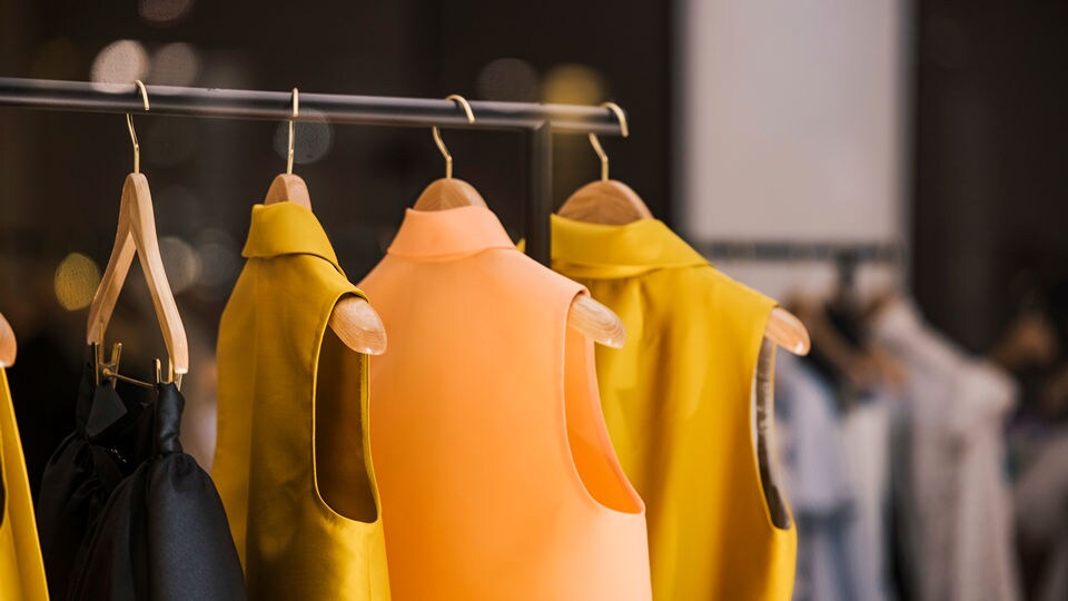 assortment of womens blouses hanging on hangers on a rack in an upscale retail apparel store