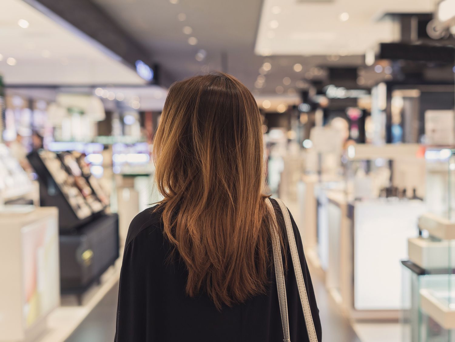 小売店の通路を歩いて女性の背面図