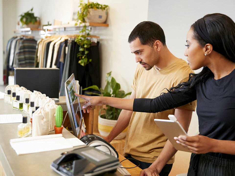 female retail consultant demonstrating technology to male store associate